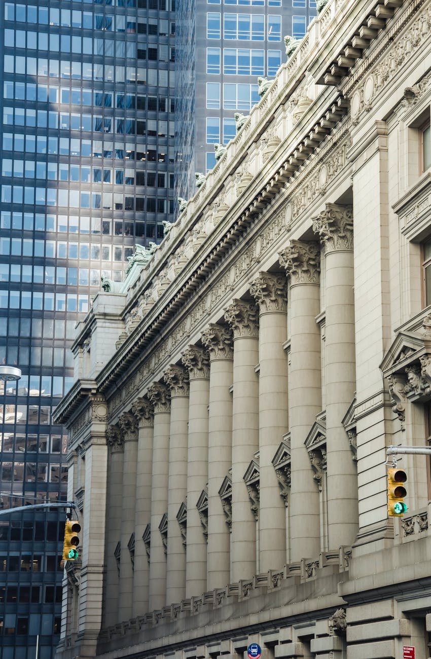 majestic stone building near glass skyscraper in downtown